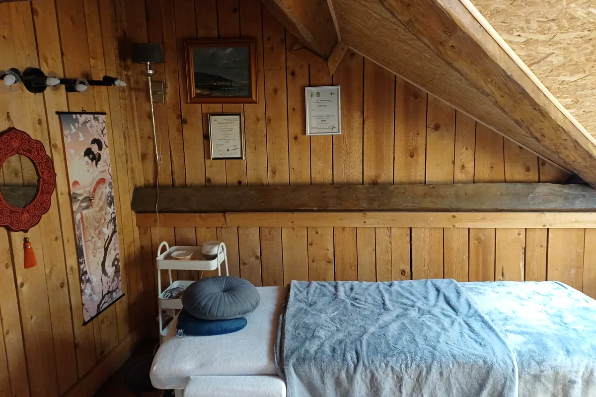 Futon de shiatsu sous la charpente en bois du dojo, avec les certifications de la praticienne